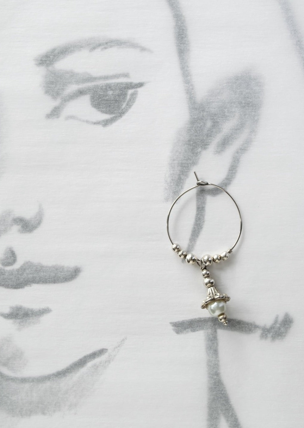 Pearls dangle hoop earrings feature a 1-inch hoop with silver beads, and a silver lily with a fresh-water pearl in the end of its bell. Overall length is approximately 1-3/4-inch.