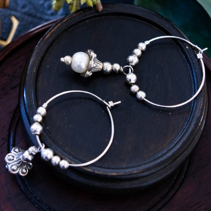 Pearls dangle hoop earrings feature a 1-inch hoop with silver beads, and a silver lily with a fresh-water pearl in the end of its bell.  Overall length is approximately 1-3/4-inch.