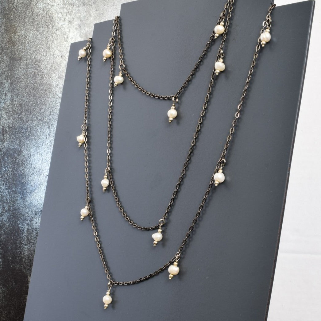 54''Fresh Water Pearl Necklace with Antiqued Chain and Dangling Pearls on display 