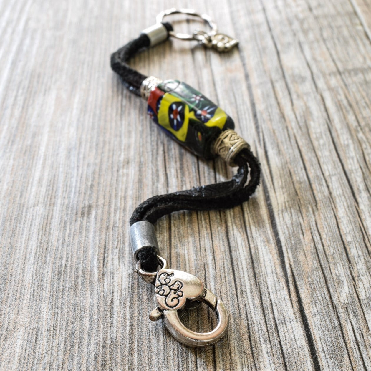 Soft Surrounds, Black Leather Bracelet with Multi-Colored Glass Bead, a Silver Heart, and a Lobster Claw Clasp