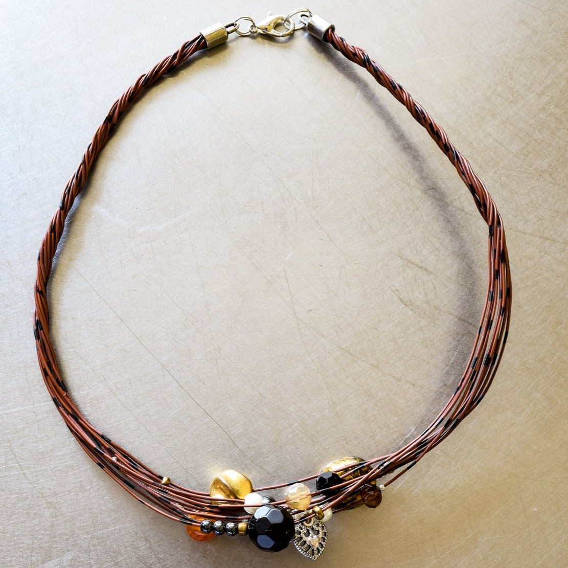 Strands, Brown with Black Wire Necklace with Glass, Stone, and Metallic Beads, and a Heart Charm