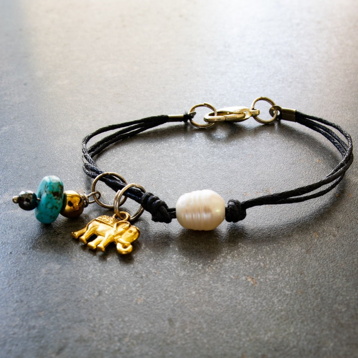 Istanbul, Black Strands Bracelet with a Gold Elephant, Turquoise, and a Fresh Water Pearl